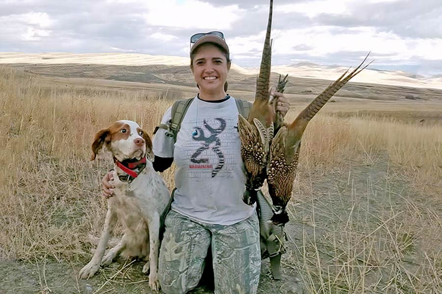 Angie Wonnacott and her hunting dog with two harvested pheasants