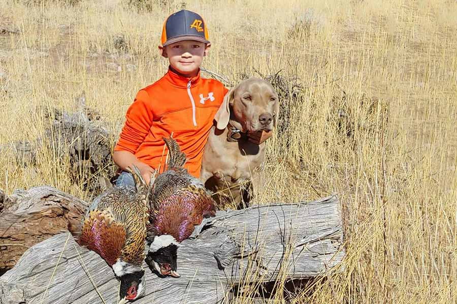 Bronx Withers with a hunting dog and two harvested pheasants