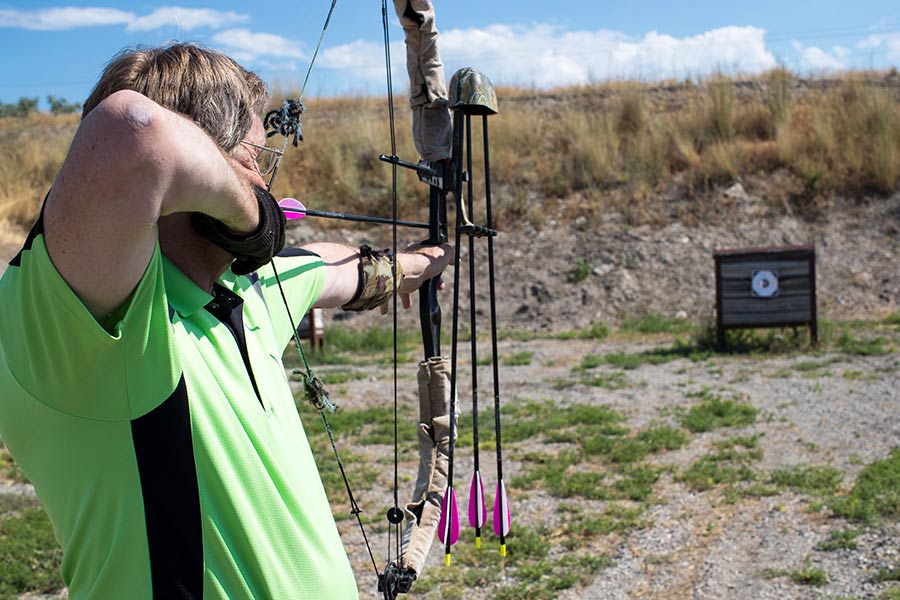 Man shooting a arrow at an archery range at Lee Kay